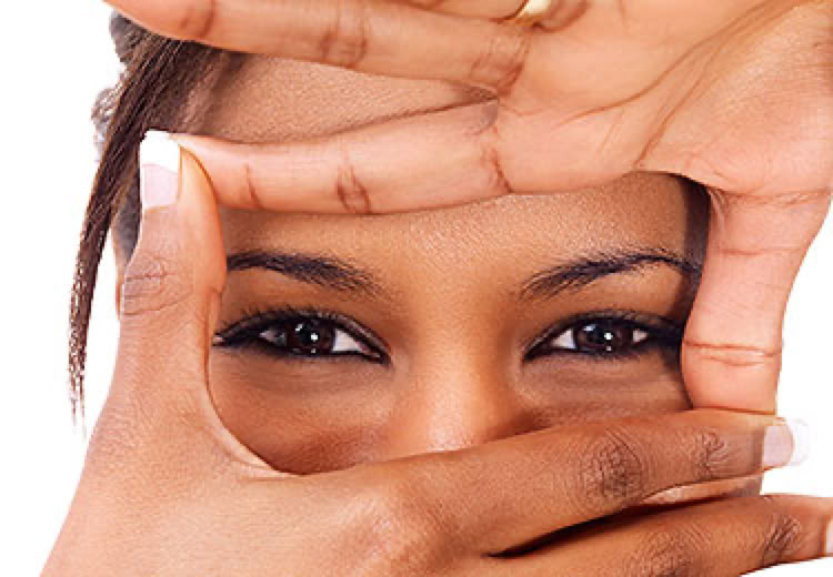 A person framing their eyes with their hands, creating a rectangle shape.